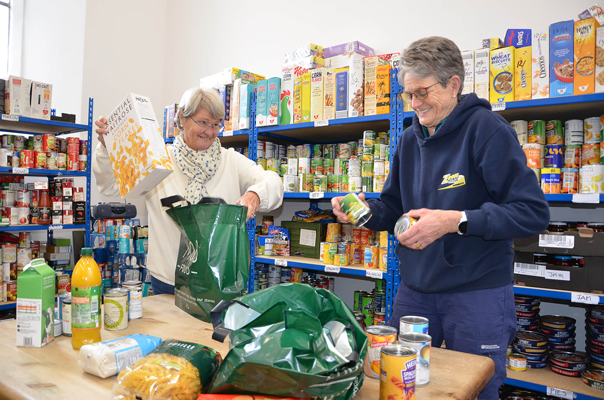 two women pack food parcels