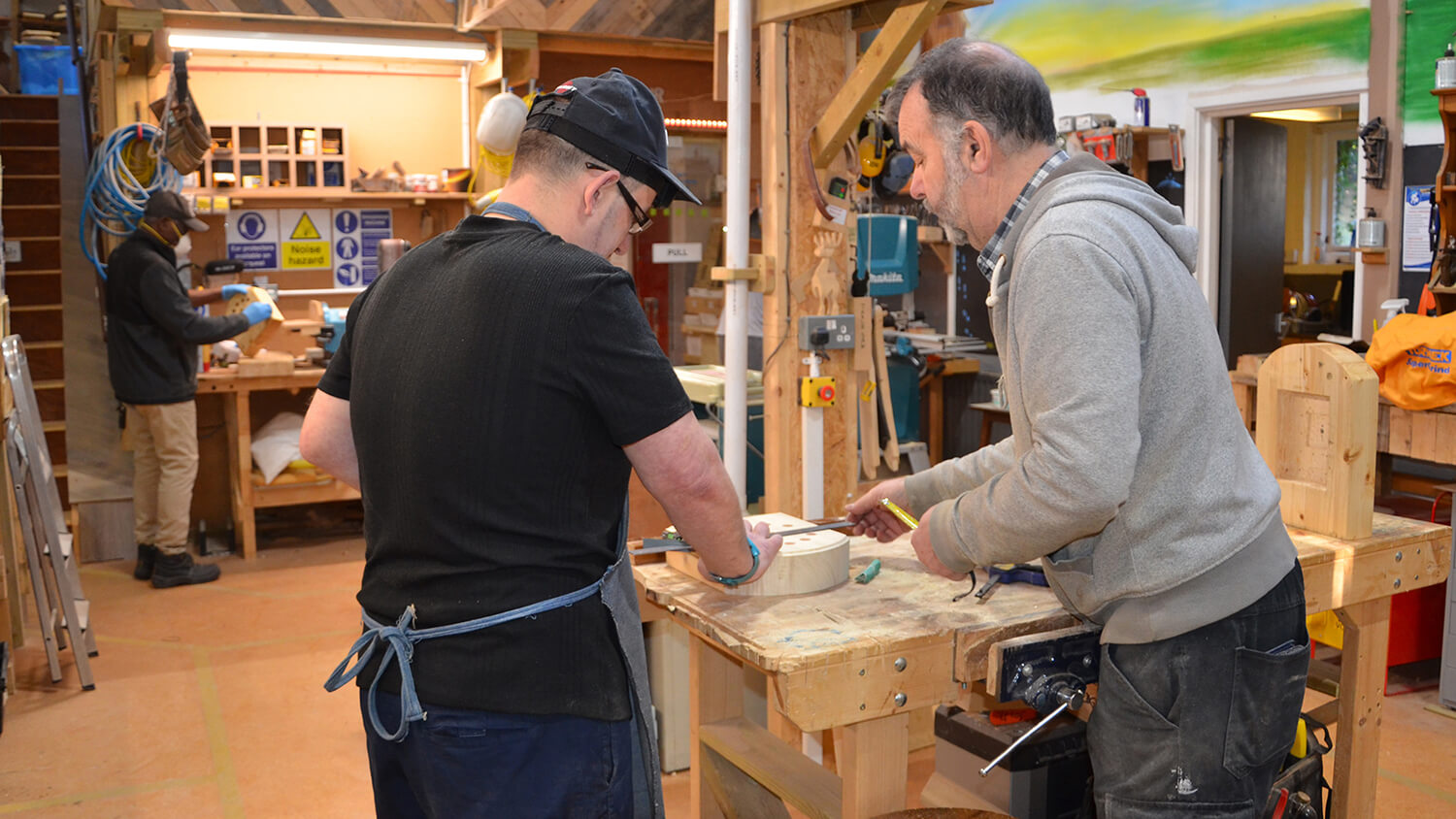 Two men standing at a woodwork bench