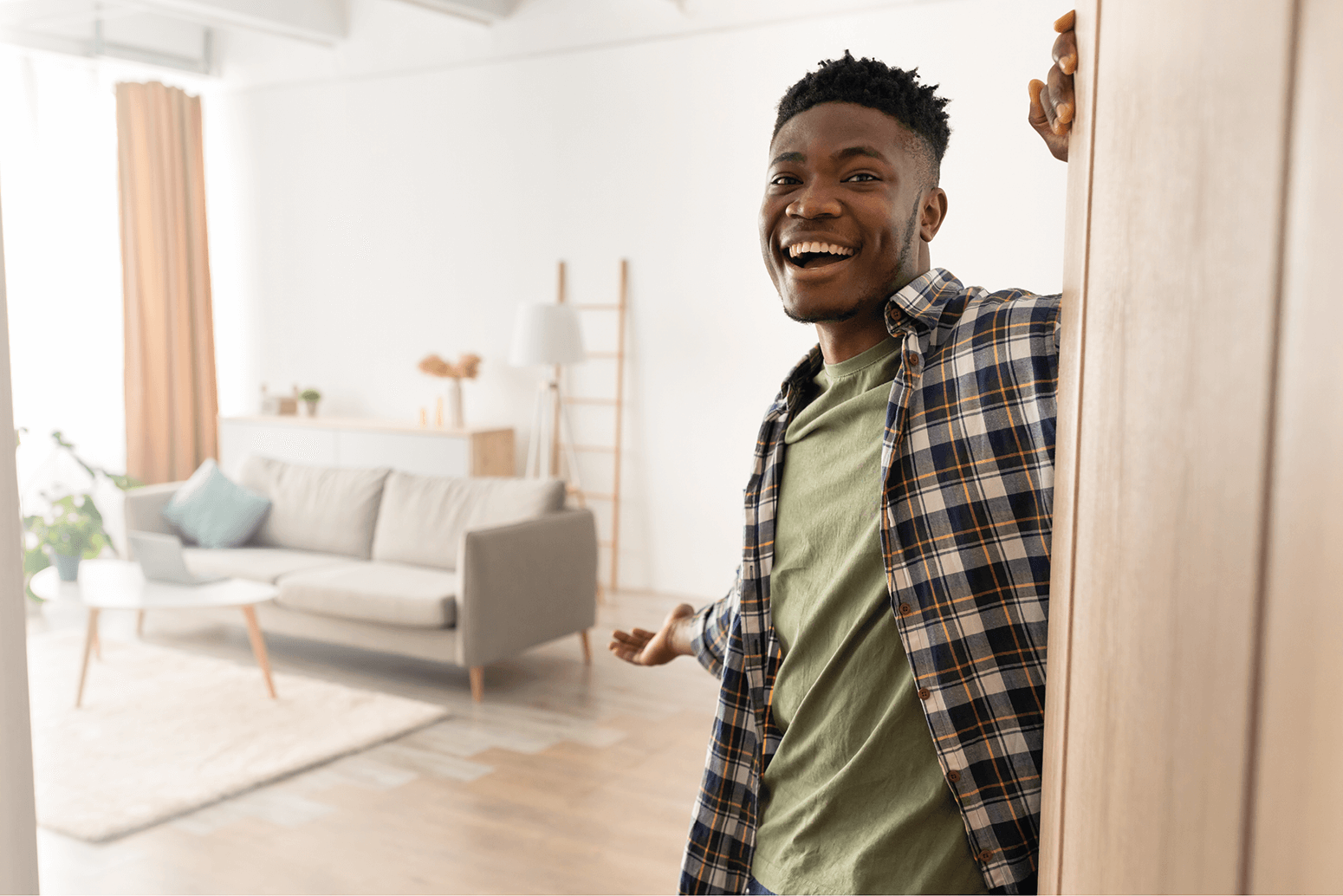 Man who stands by open door with hand pointing to a lounge