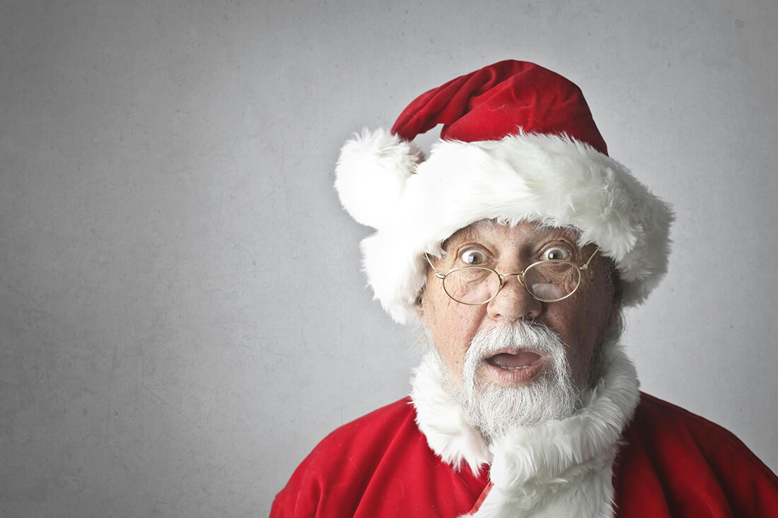 A man dressed as Santa and looking surprised