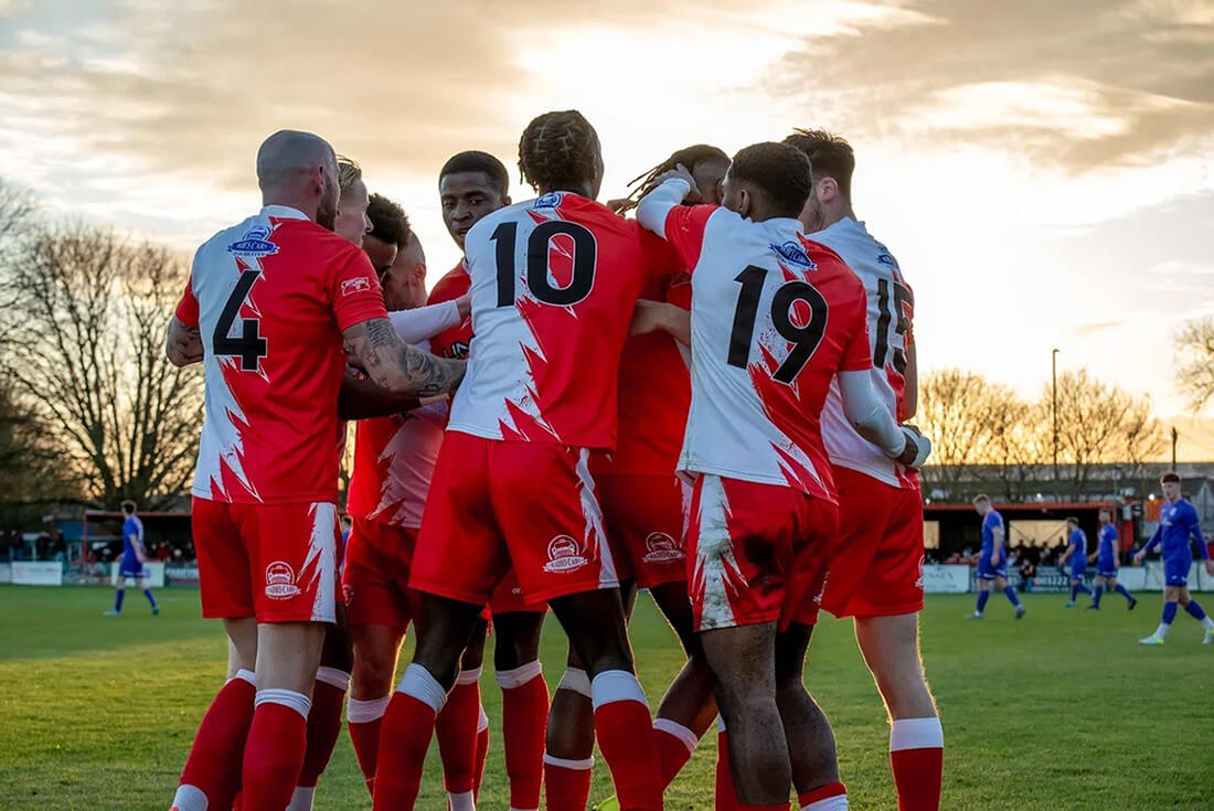 A group of footballers get together in a huddle